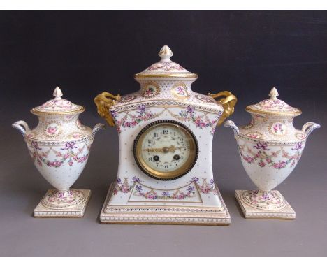 A French porcelain mantle clock garniture, with a French movement and two twin handled vases and covers standing on square pl