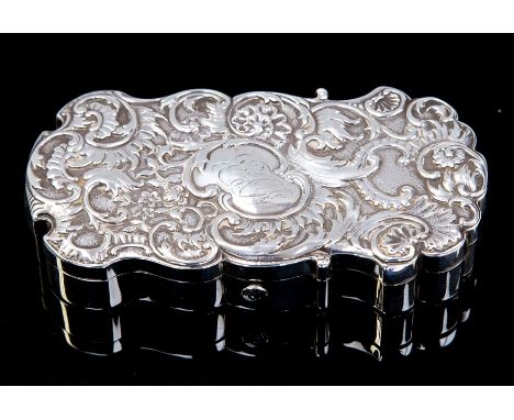 A Victorian silver cartouche shaped necessaire, the hinged cover chased with scrolling foliage and central cartouche engraved