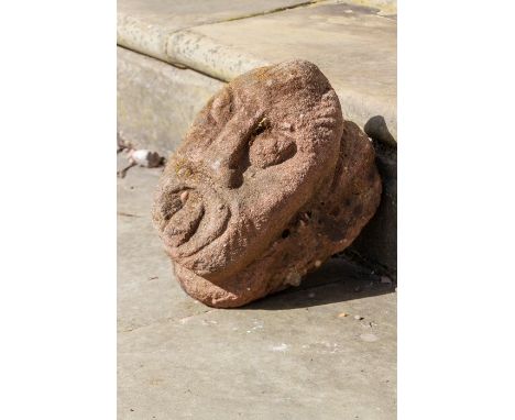 A carved head of grotesque form - architectural salvage