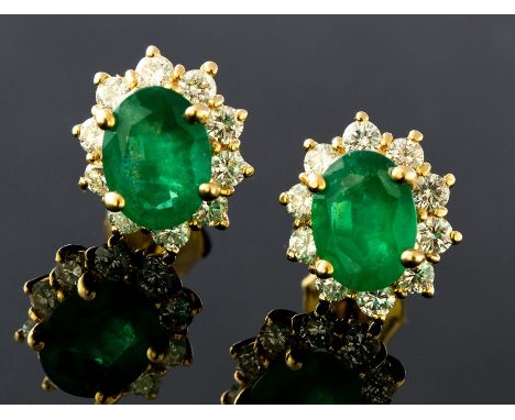 A pair of emerald and diamond oval cluster 18ct gold stud earrings, the two central oval cut emeralds weighing approx, 1.0 ca