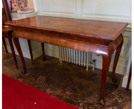 An early 18th Century Irish design walnut side table, with yew-wood oyster veneer crossbanding, the frieze carved with foliat