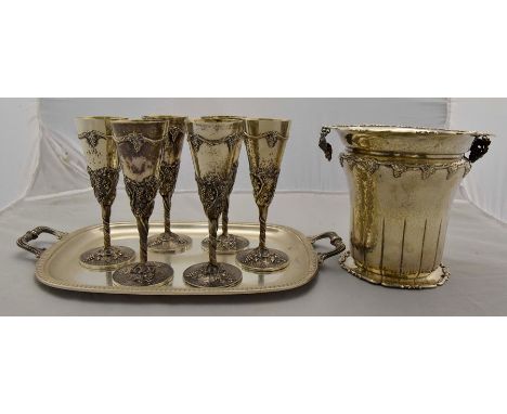 A set of six white metal Continental possibly Italian hammered champagne flutes with gilt bowls, the bodies chased with bunch