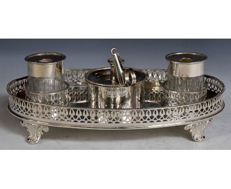 A 19th Century silver plate oval inkstand, with&nbsp;pierced gallery rail on four scroll feet, with a pair of glass ink bottl