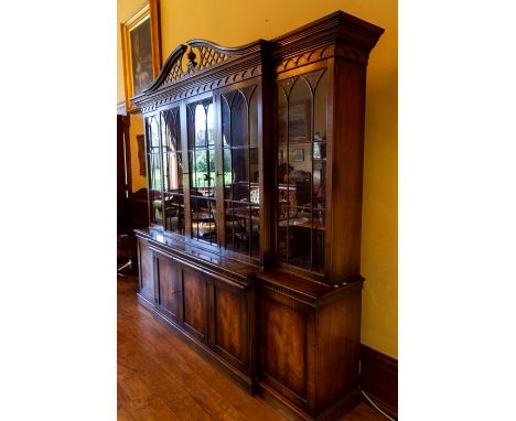 A George III style mahogany break front bookcase, of recent manufacture, the upper section with a shaped broken [pediment wit