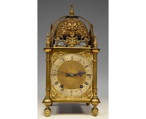 A late 19th Century traditional brushed brass lantern clock of large size, flame finial and fret scroll mounts to the pedimen