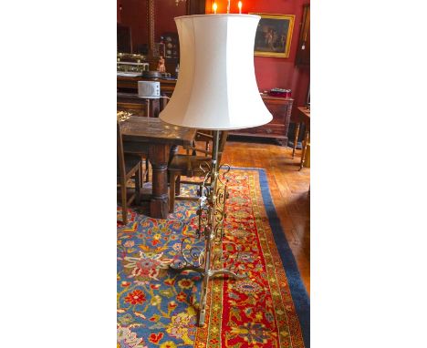 A gilt metal standard lamp complete with a cream shade