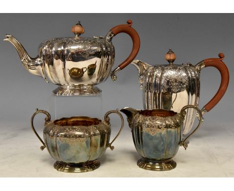 An Elizabeth II silver four piece tea service including teapot, hotwater jug, milk jug and sugar bowl, bulbous bodies with fl