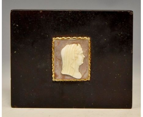 An early 19th Century black marble paperweight set with a yellow metal mounted shell cameo portrait of a lady in profile wear