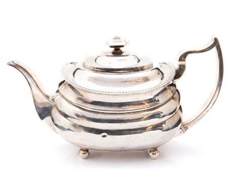 A George III silver lobed teapot, the 'C' scroll handle ensuite with ivory insulators, gadrooned decoration on four ball feet