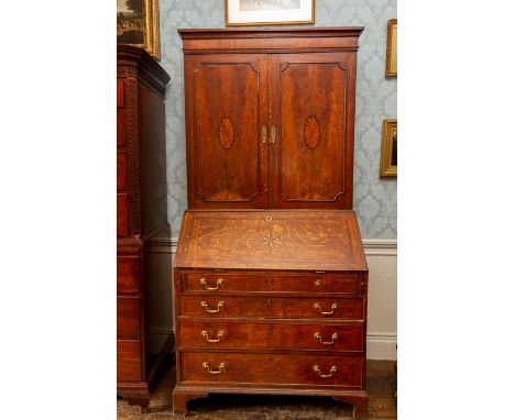 A George III oak bureau bookcase, the upper section possibly a marriage, fitted with two doors inlaid with panels of paterae,