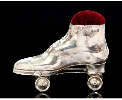 An Edwarian silver novelty silver pin cushion modelled as a roller skate boot with rotating axle and wheels, brown cushion, B