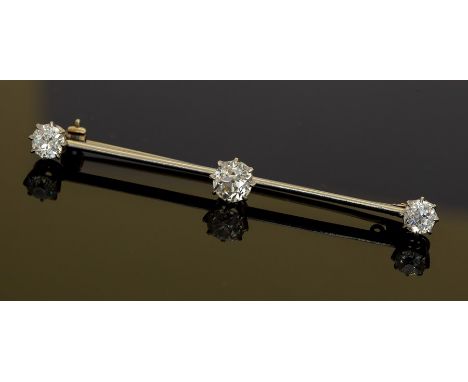 An Edwardian diamond three-stone bar brooch, three round old cut diamonds, the centre diamond weighing approx. 1.0carat, the 