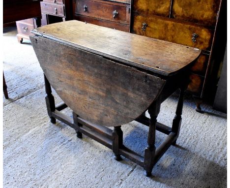 An antique oak drop leaf dining table on gate leg action base