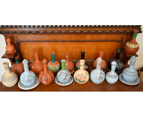 Seventeen Victorian ceramic water-cooler bottles, seven with stands and eight with covers