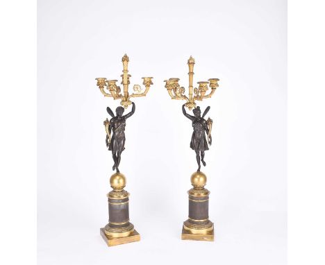 A pair of French parcel gilt bronze figural candelabraCirca 1900Each with a winged classical figure holding aloft four scroll