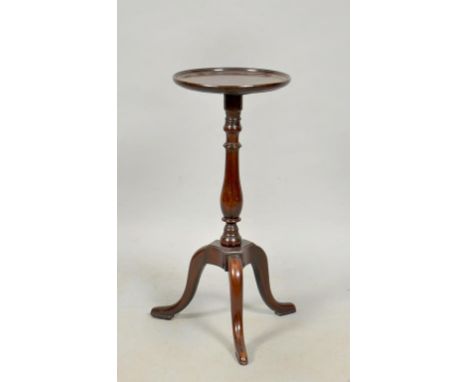 A late Georgian mahogany circular pedestal tripod table, the circular dished top supported on a baluster ring turned column r