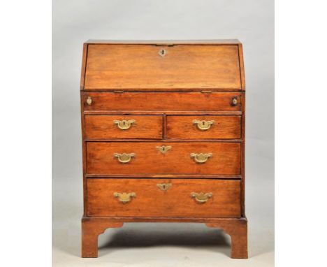 A George III oak country bureau of small proportion, with fall front and fitted interior, containing a well over two short an