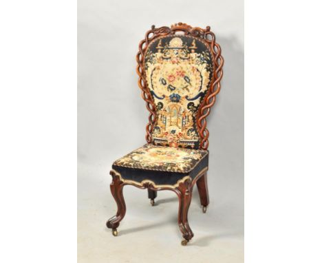 A mid Victorian rosewood upholstered side chair, the back panel within a guilloche carved border and supported on carved and 