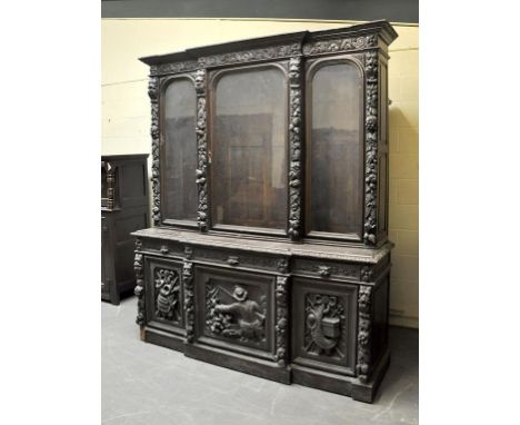 A 19c oak library bookcase, slightly breakfront, the glazed bookcase supported on cupboard base with three frieze drawers, ov