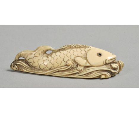 A Japanese Meiji period netsuke carved as a fish amongst the waves, base signed, 3l.