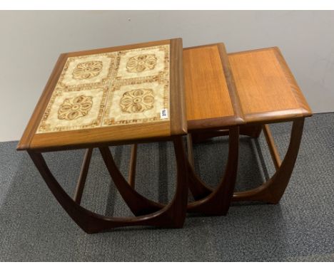 A nest of three G-plan teak tables largest with a tile top, 50 x 50 x 51cm.