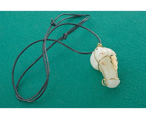 A jade pendant dating: 19th Century provenance: Asia In the round depiction of a horse head, white jade with gold features. C