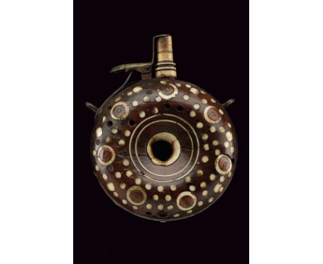 A powder-flask dating: circa 1600 provenance: Germany Circular, doughnut-shaped body, the central hole is covered by a bone d
