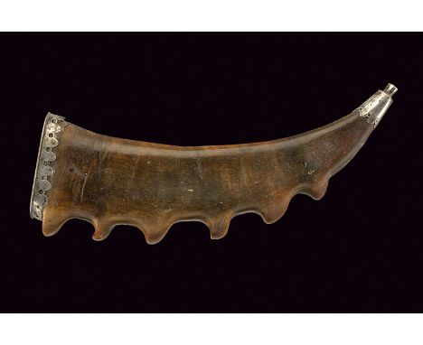 A powder-flask dating: 18th Century provenance: Germany Of ibex horn, curved shape. Silver fuse with long ring-nut at the bas