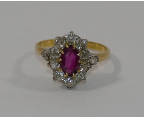 A ruby and diamond oval cluster ring, the mixed cut central ruby claw set within 10 old round brilliant cut diamonds, combine