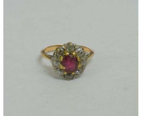 An 18 carat gold ruby and diamond oval cluster ring, the oval mixed cut ruby approximately  0.70 carats, the eight old cut di