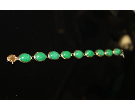 A 14KT GOLD LADIES BRACELET INSET WITH JADE GREEN
