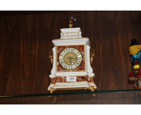 A GILDED CERAMIC MANTLE CLOCK