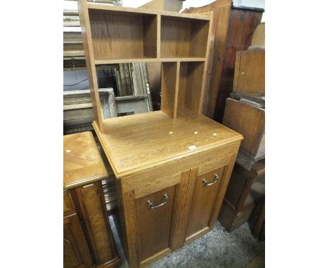 A LIGHT OAK CABINET WITH STAGED BACK