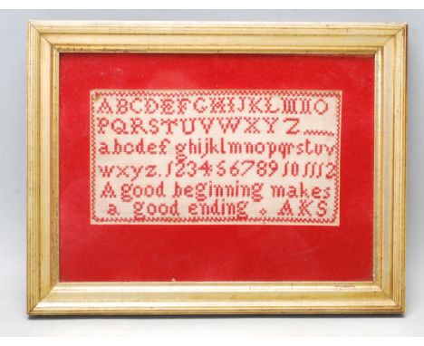 A 19th Century Victorian needlework sampler having the alphabet stitched to the top and motto ' a good beginning makes a good