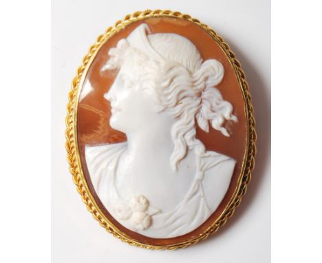 A large late 19th / early 20th Century cameo brooch set with a large carved conch shell cameo portrait set within a 9ct rope 