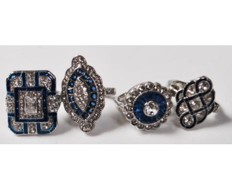 A group of four contemporary Art Deco style white metal dress rings to include a ring with a square head set having blue enam