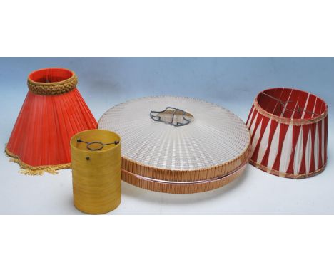 A collection of four retro vintage light shades to include a UFO textured plastic shade, a cylindrical amber shade, a red fab