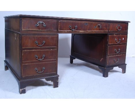A 20th century antique style Victorian revival mahogany twin pedestal desk having a green leather gilt tooled skiver over two