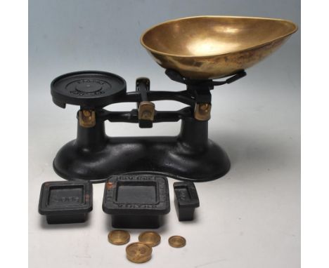 A vintage 1950’s cast iron Victor shop scale having a teardrop shaped brass tray, pedestal base, complete with two cast iron 