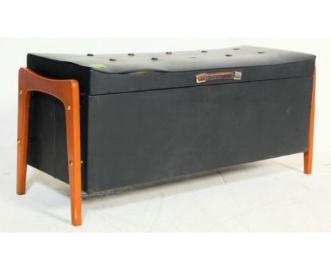 A vintage 1970’s black vinyl ottoman stool having button seat raised on tapered angular supports. H40cm x W100cm x D37cm