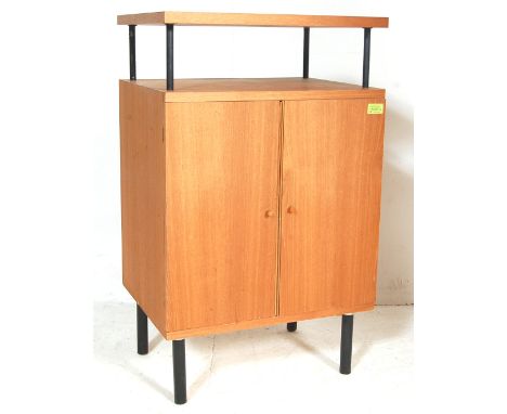 A vintage 1980’s teak wood pedestal bedside cabinet having a rectangular floating shelf above a twin doors cupboard raised on