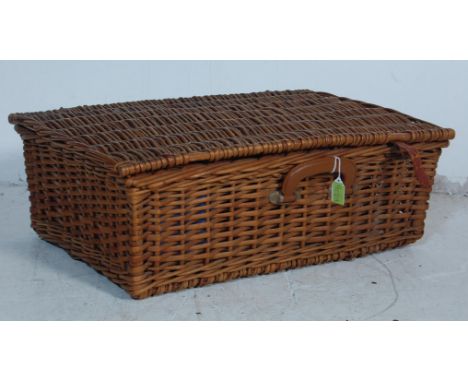 A vintage late 20th century 1970s picnic wicker hamper / basket having a hinged lid opening to reveal a a fully appointed int