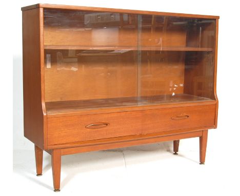 A vintage retro G Plan teak wood bookcase having a glazed front bookshelf to the top with one shelf within above twin doors w
