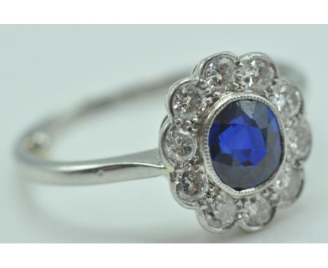 An early 20th Century Edwardian white gold sapphire and diamond cluster ring having a central oval cut blue sapphire millegra