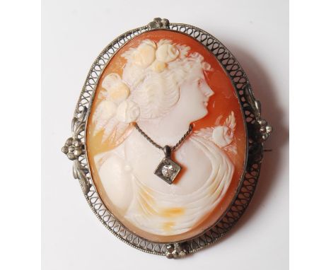 A 20th Century large silver white metal cameo brooch having an oval carved conch shell cameo portrait with applied metal pend