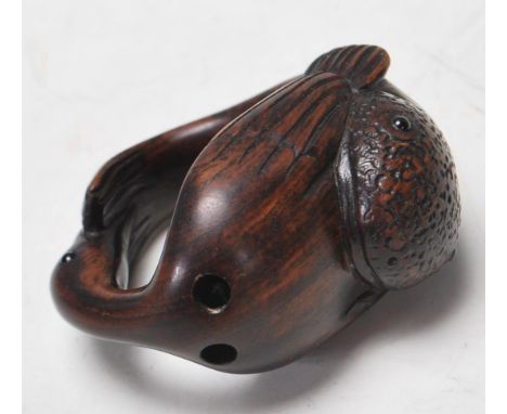 A 20th century Japanese carved hardwood netsuke depicting a bird eating a fish. Makers signature to the base. Measures 4cm in