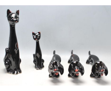 A collection of five Italian stylised elongated ceramic figurines of cats and dogs having black backgrounds with silver featu