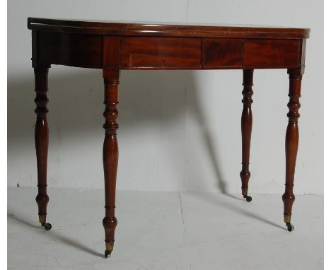 An antique 19th century George III mahogany card table / tea table / games table having a metamorphic hinged top with rounded