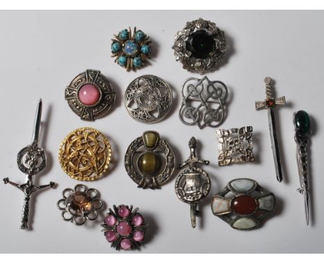 A collection of 15 various brooches to include a selection of Celtic / Scottish brooches including a green stone and thistle 