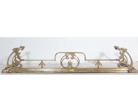 A 19th Century Victorian antique Art Nouveau brass fire fender / fireguard / kerb having a sloped edge with typical art nouve